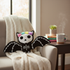 Decorative pillow with skeleton design and floral accents on a couch in a cozy living room.