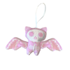 Pink bat-shaped plush toy with skeleton face on a white background