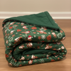 Folded green blanket with festive pattern on a wooden surface