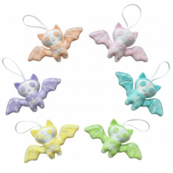 Set of six pastel-colored bat-shaped keychains on a white background