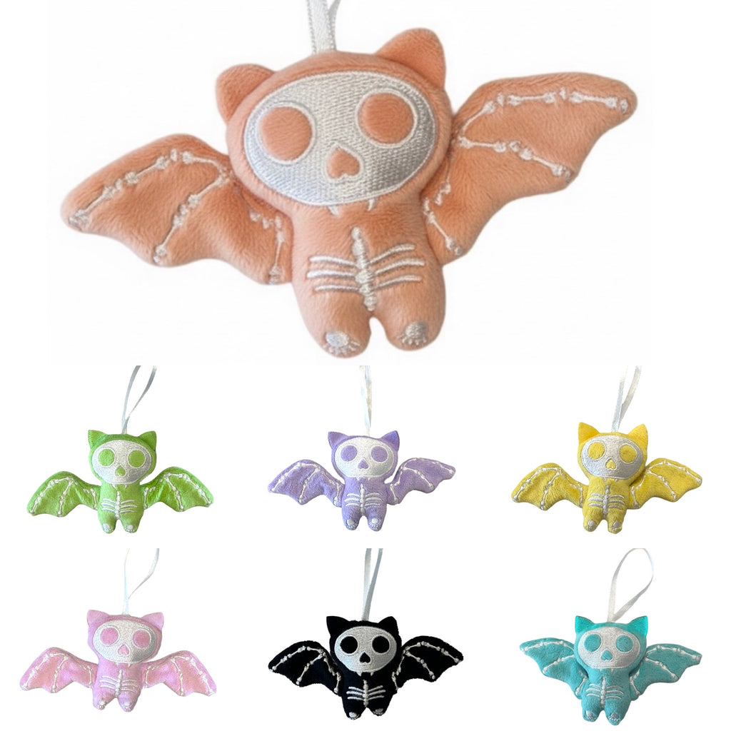 Set of colorful bat-shaped plush toys on a white background